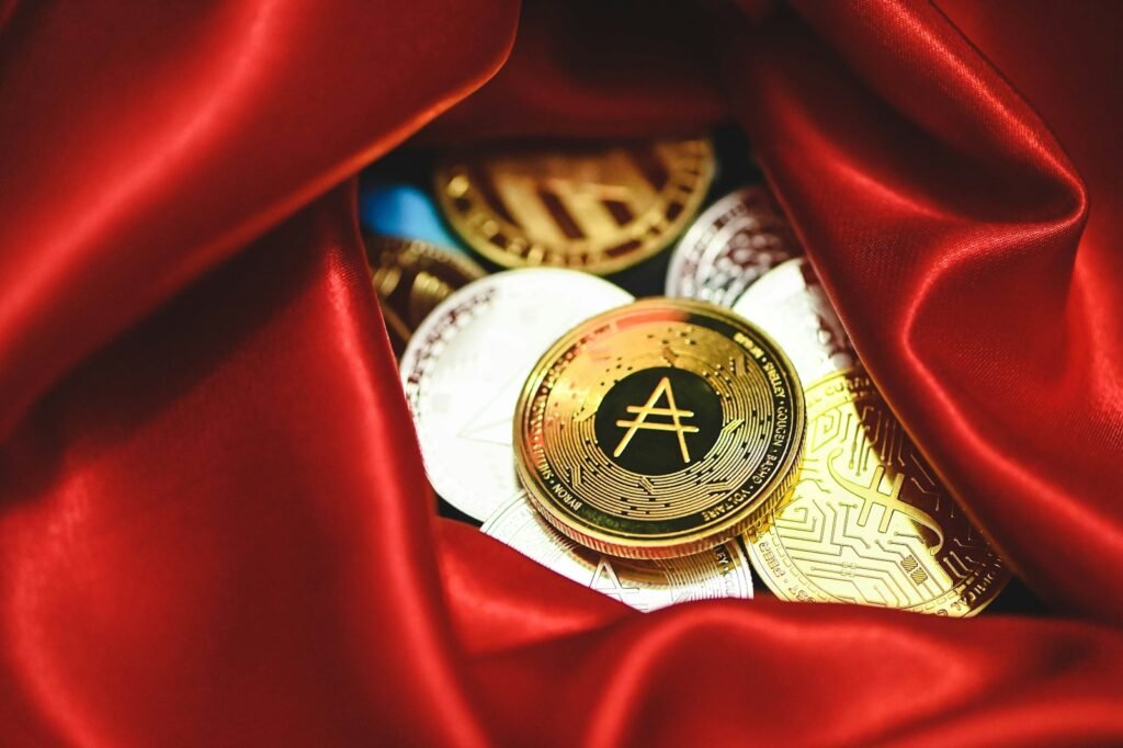 a pile of gold and silver coins sitting on top of a red cloth