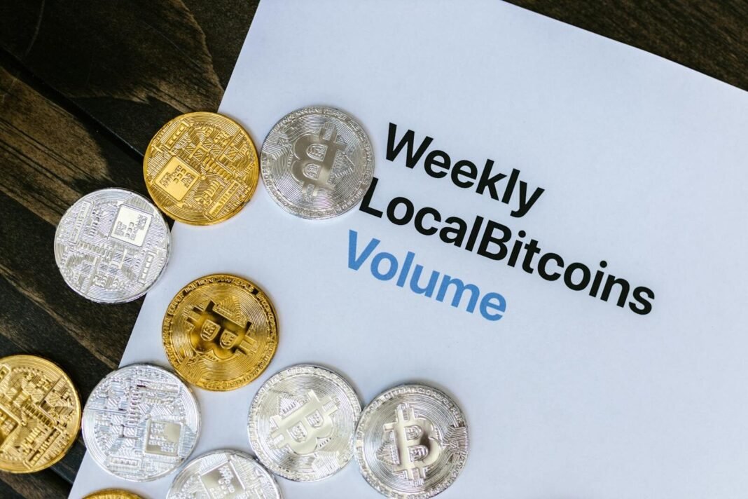 Image of Bitcoin tokens on a Weekly LocalBitcoins volume report paper.